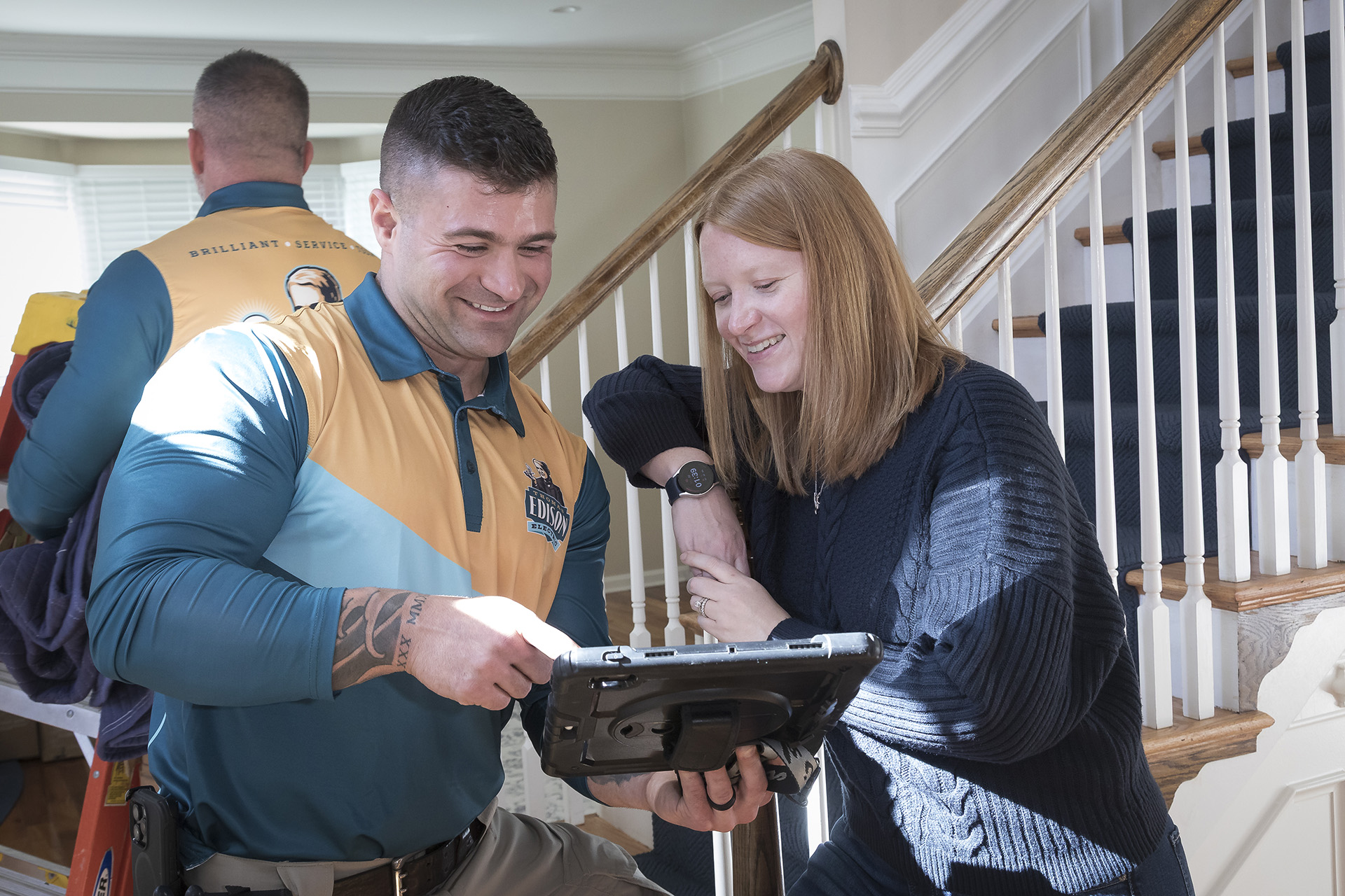 Electrician With Client - Orlando Electrician | Thomas Edison Electric Electrician reviewing project details with client on a tablet