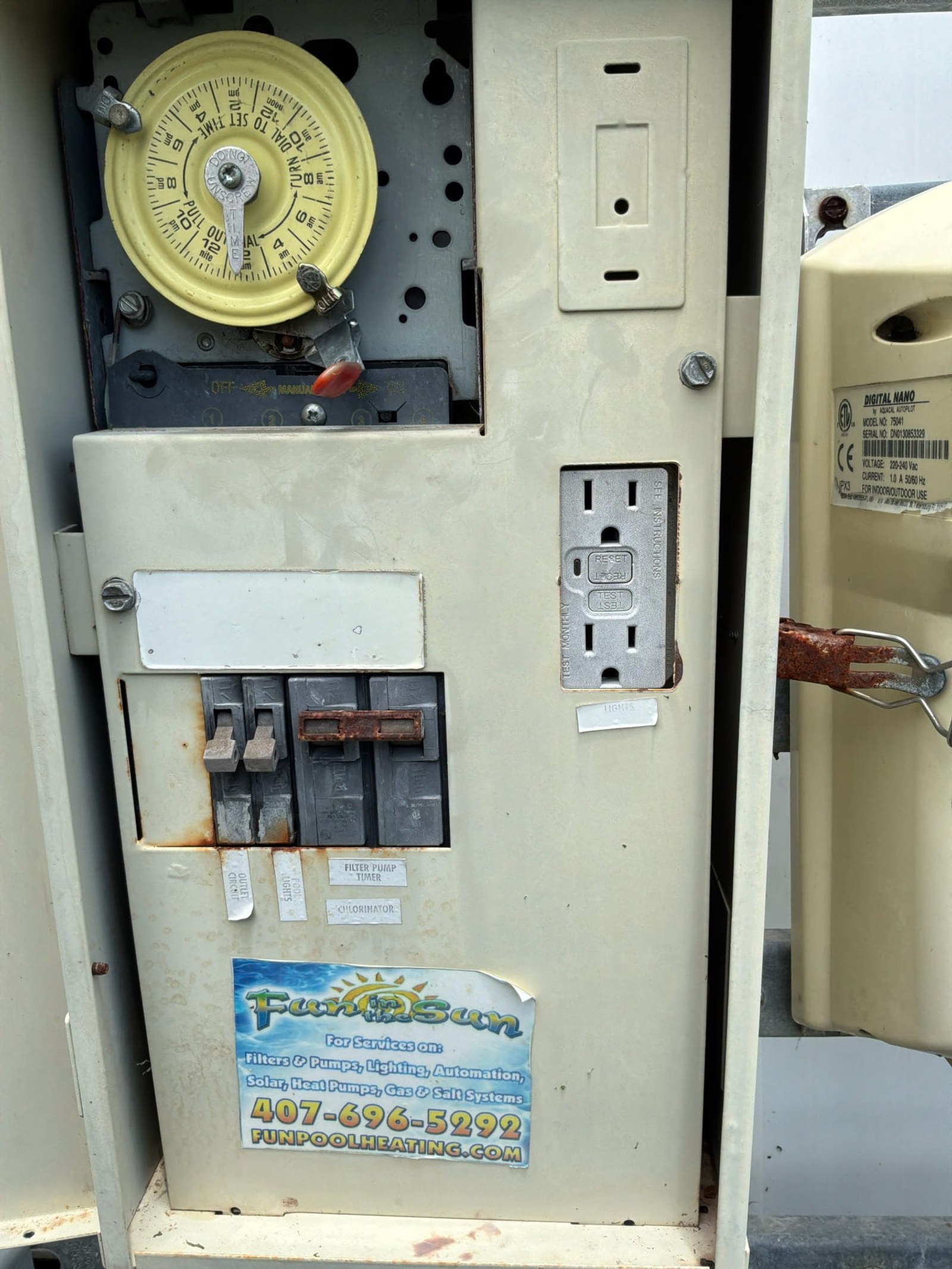Pool equipment sub-panel with time-clock timer, corroded breakers, unprotected outlet showing lack of surge protection.