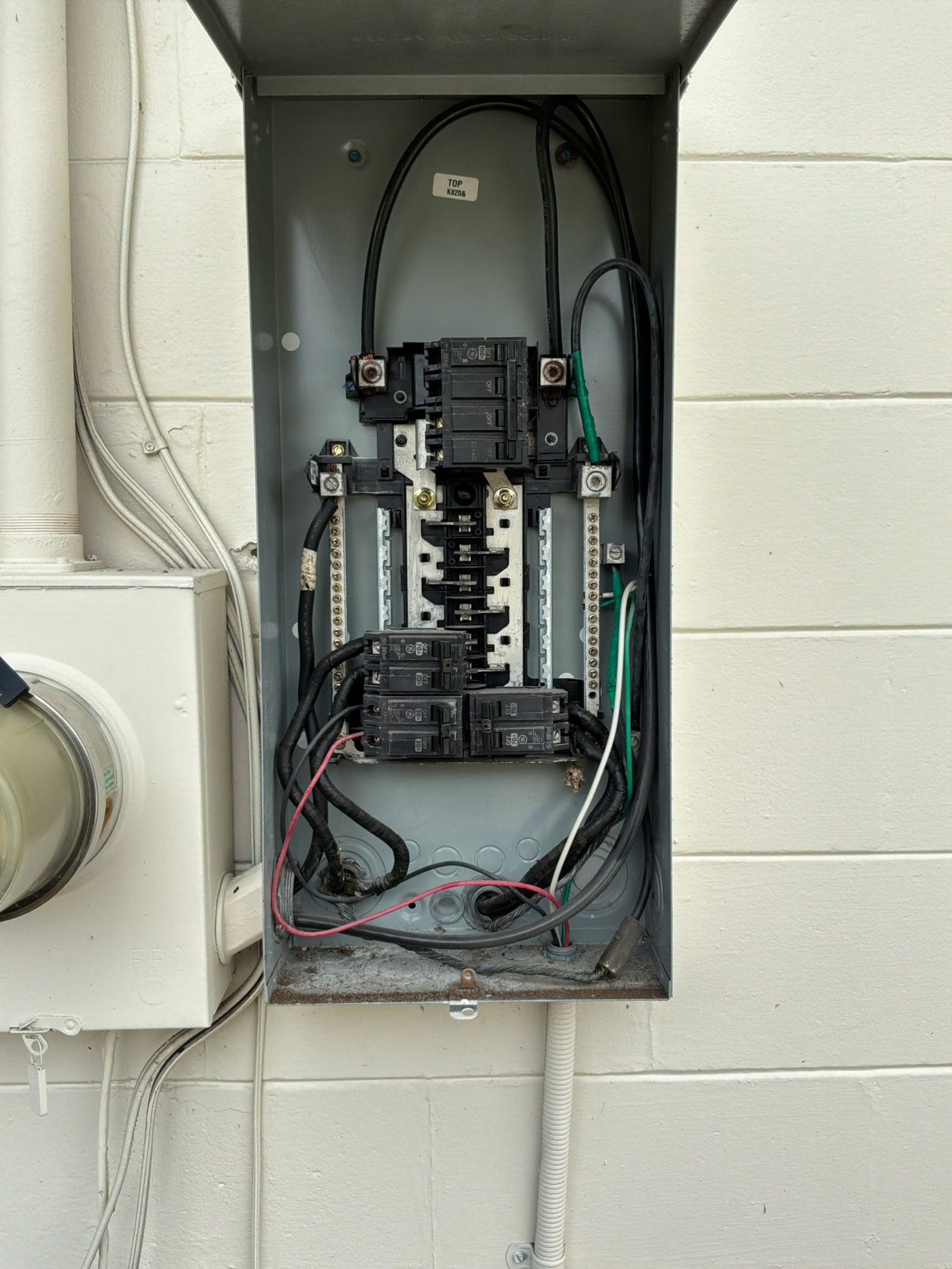 Breaker panel interior with multiple circuit breakers, heavy gauge feeder cables, and basic bussing arrangement showing absence of surge protection device.