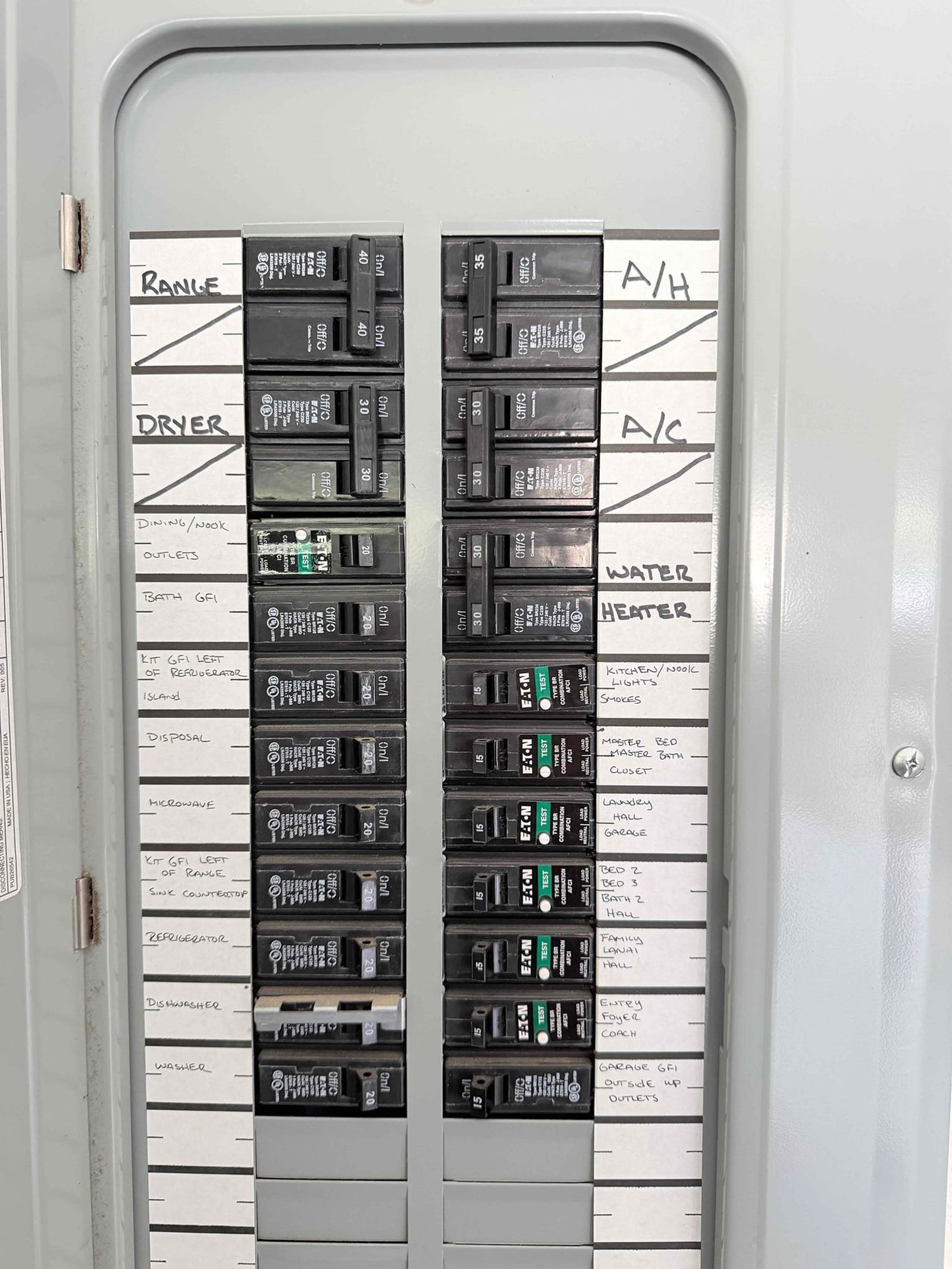 Completed main service panel interior after work, showing all breakers properly seated, circuits labeled, and organized wiring.