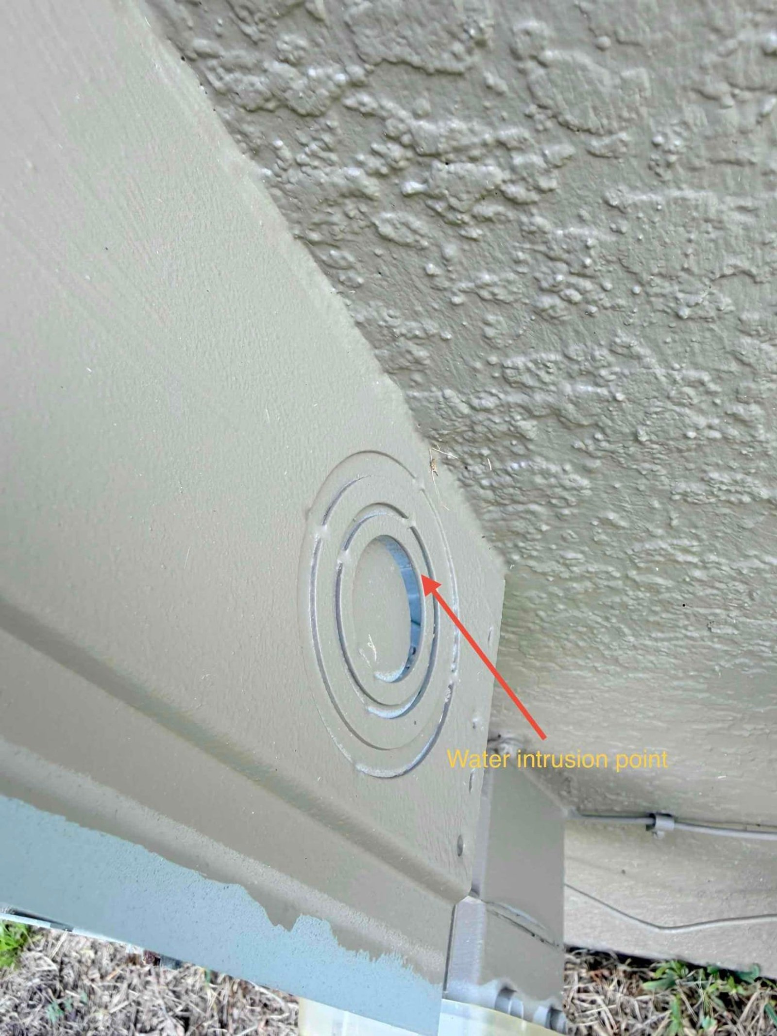 Exterior soffit showing water intrusion point at service entrance penetration with annotated water damage.
