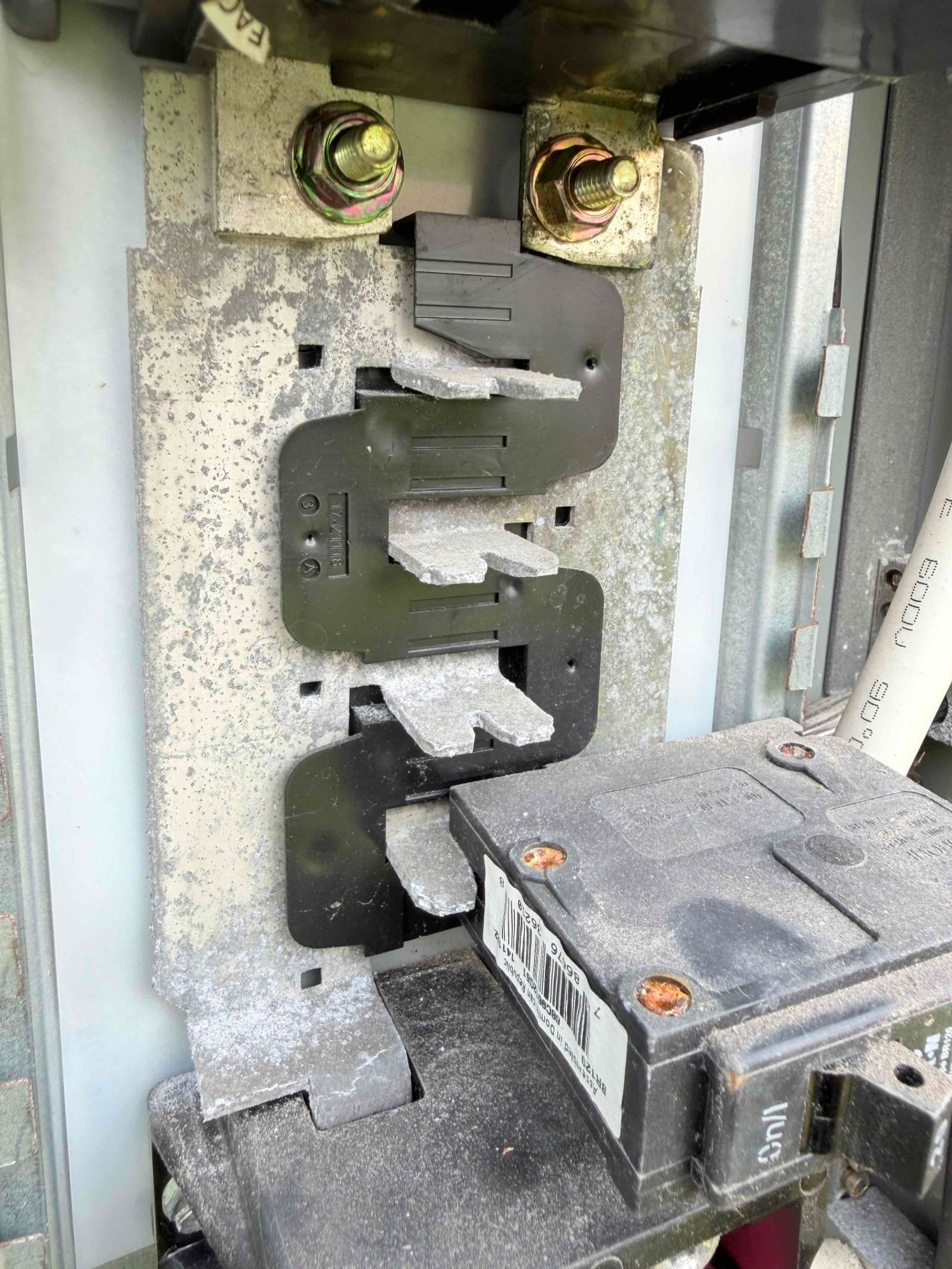 Close-up of corroded external bus bar showing white oxidation deposits and deteriorated metal connections.