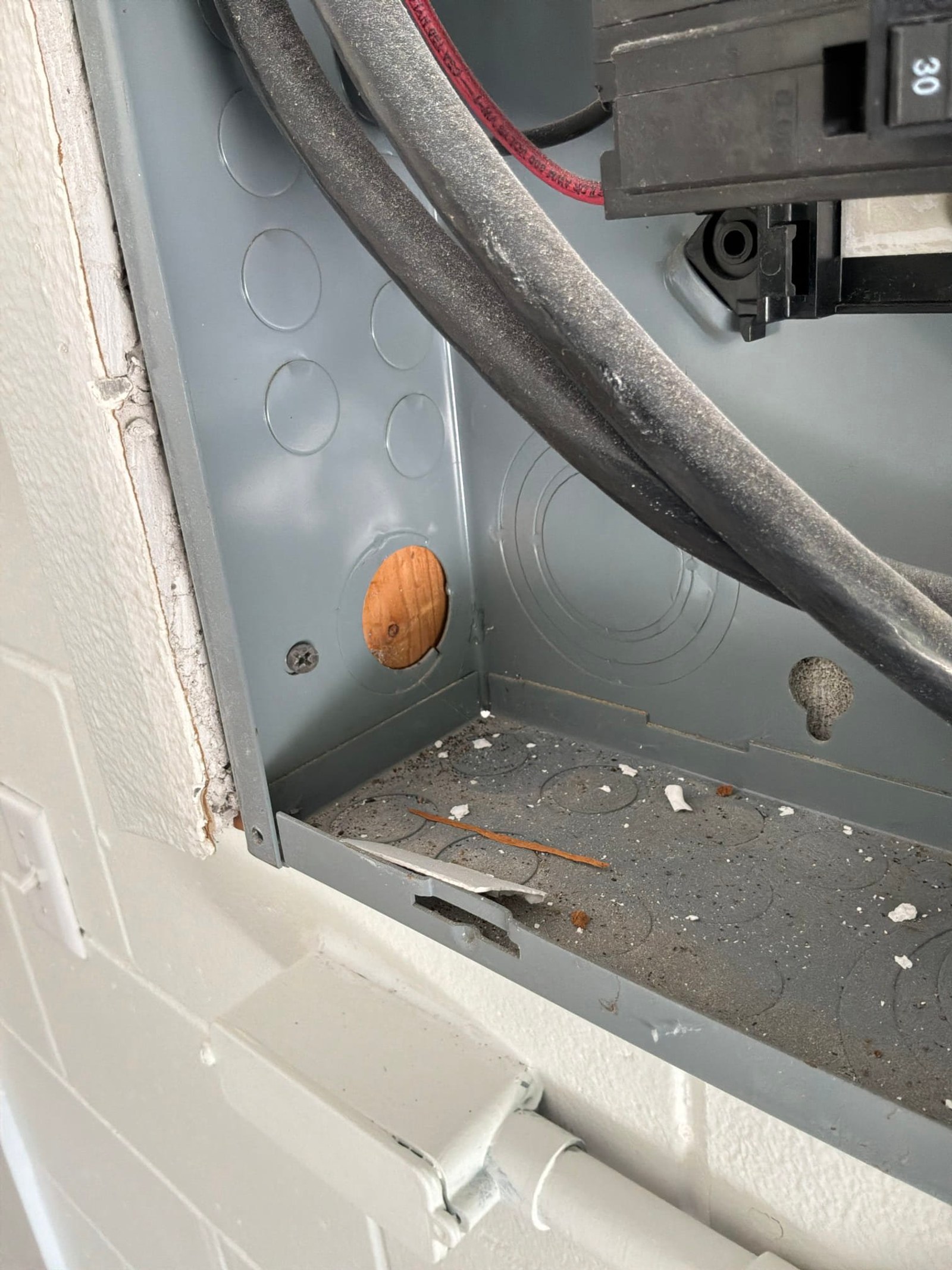 Interior panel detail showing wooden bushing plug and scattered fire debris from surge damage.